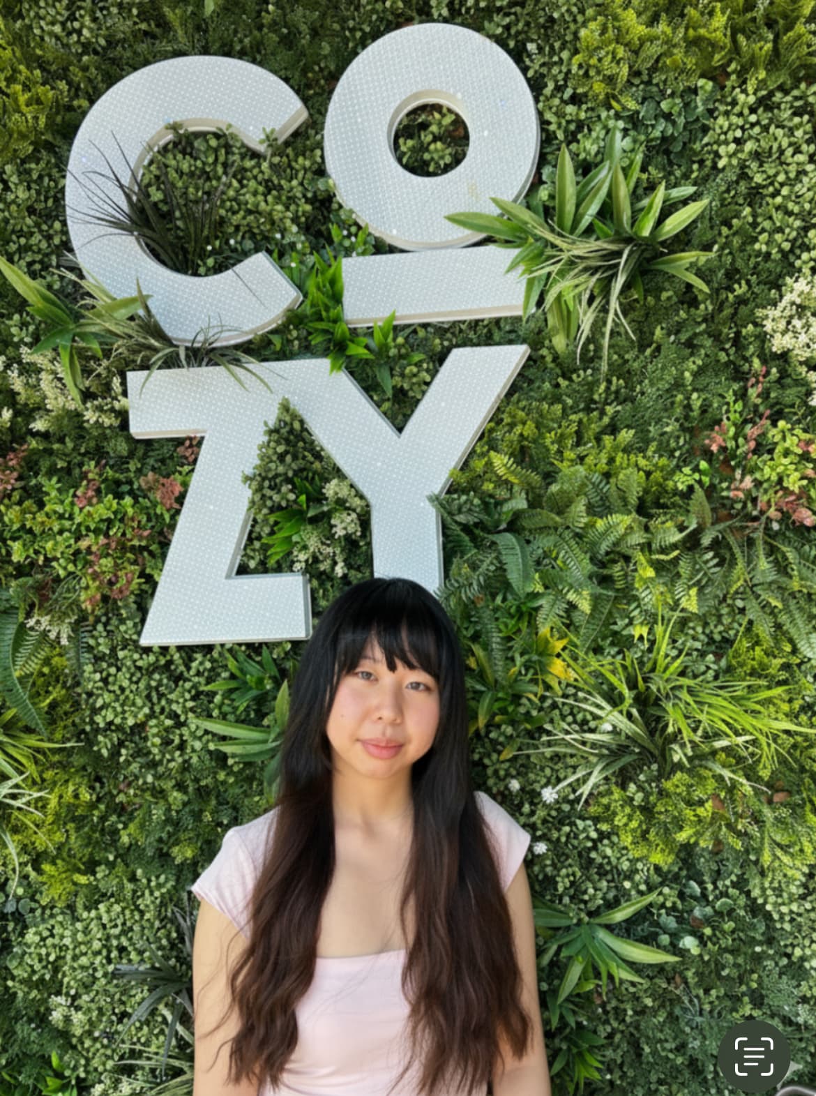 Amy in front of a cozy green wall