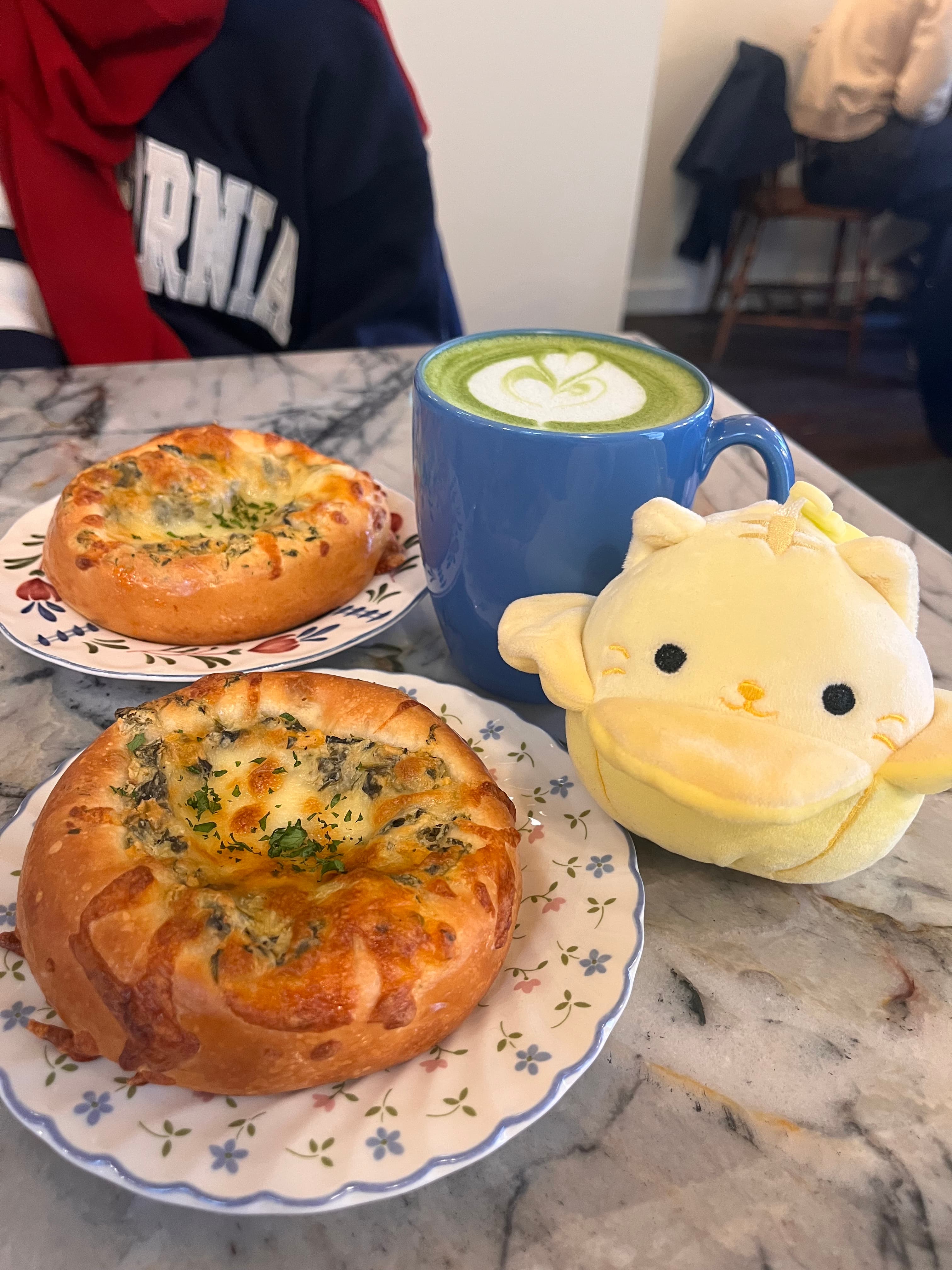 Matcha latte with Cinnamoroll plushie and garlic buns