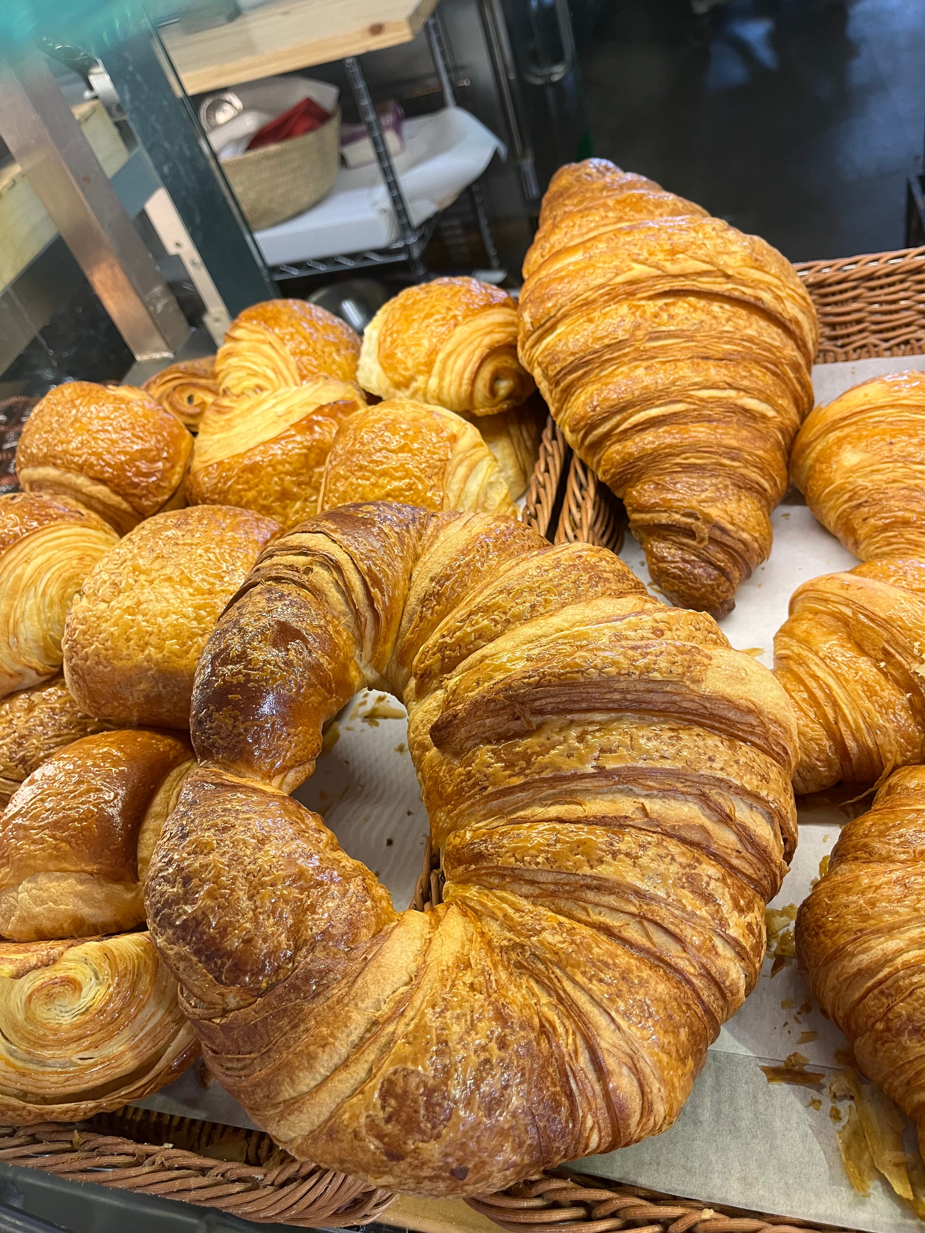Wall of golden croissants at a bakery